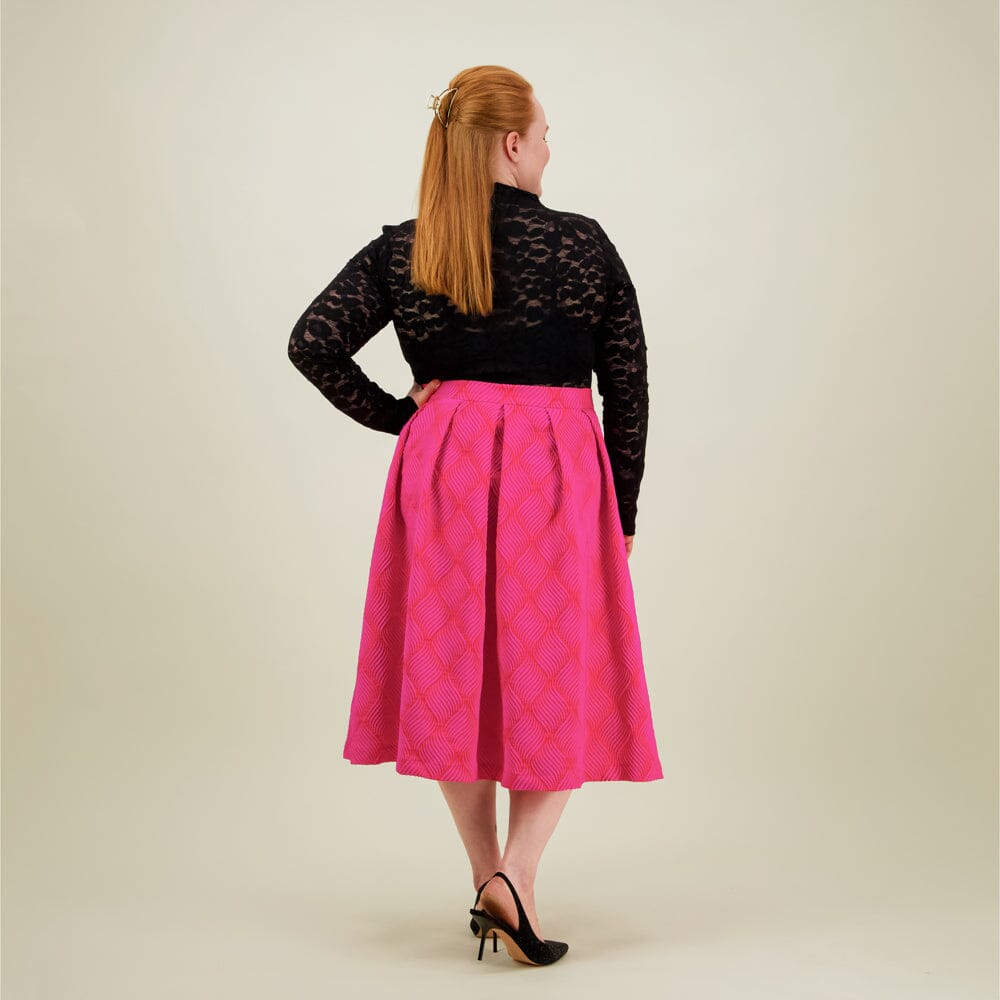 Naisten midimittainen pinkki-oranssi jacquard-hame vyötärön laskoksilla ja vetoketjukiinnityksellä, kuva takaa päin. 