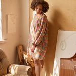 Naisten tunikamallinen viskoosimekko Cynthia De Vitin kuosilla, pitkät puhvihihat ja sivutaskut, malli seisoo nojaten seinään valon tullessa sivusta.