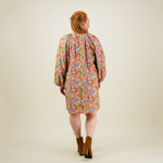 Kuva mallista takaa päin naisten tunikamallinen viskoosimekko Cynthia De Vitin kuosilla, pitkät puhvihihat ja sivutaskut