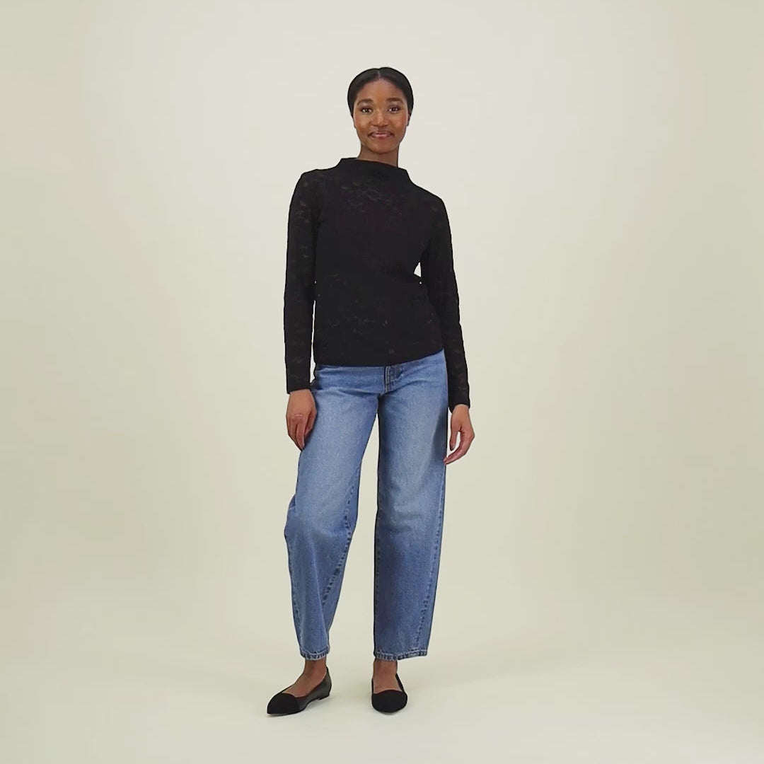 video jossa naisten musta pitsipaita korkealla kauluksella ja pitkillä hihoilla.