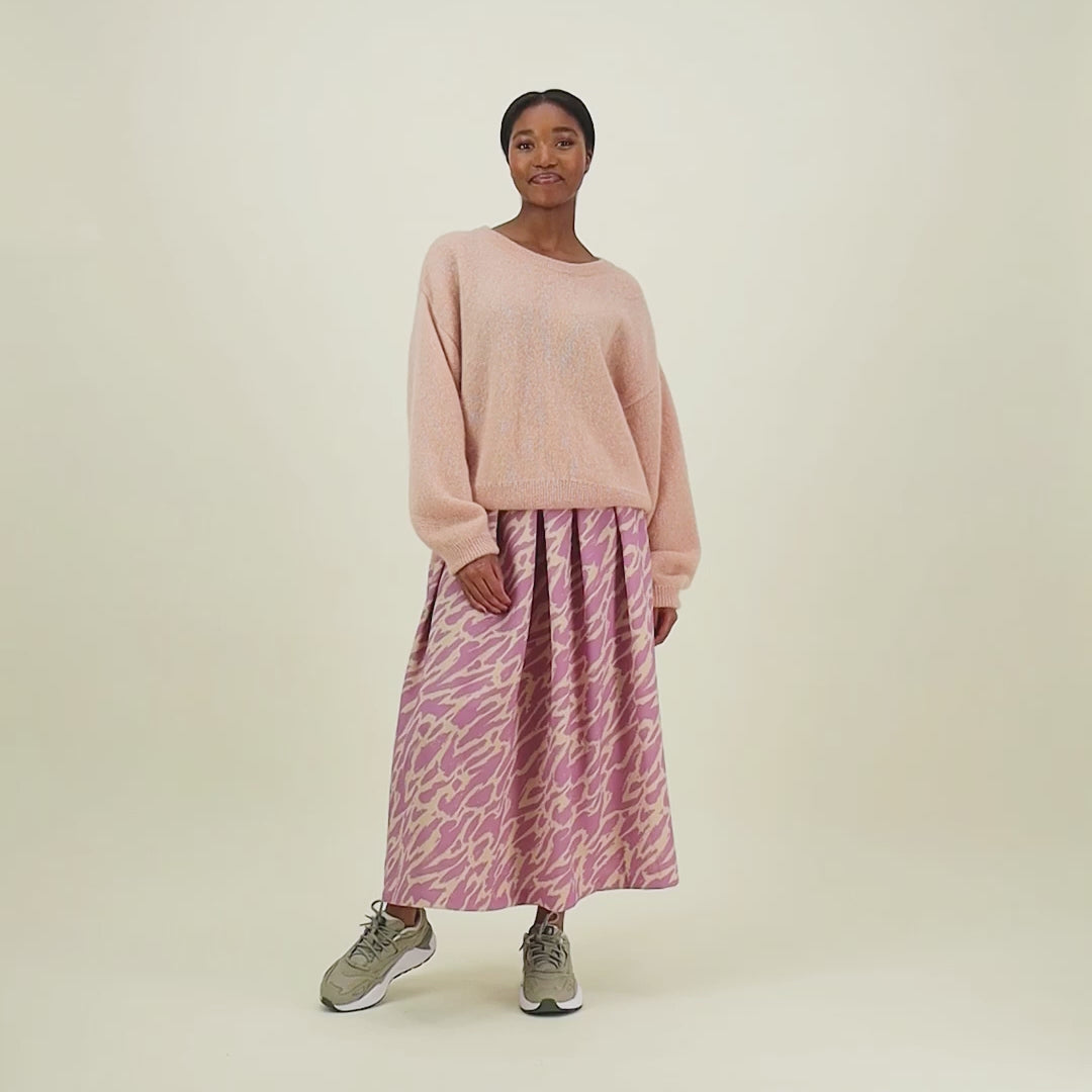 video, jossa nainen esittelee naisten midimittaisen purple-sävyisen laskostettu hame kierrätyspolyesterista, joustavalla vyötäröllä ja sivutaskuilla."