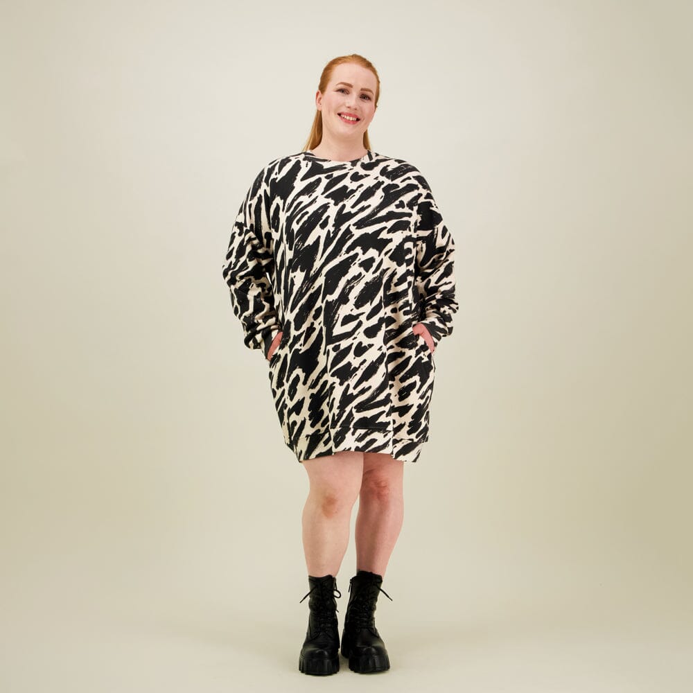 Naisten oversize-mallinen polvimittainen mustavalkoinen collegemekko sivutaskuilla.