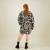 Naisten oversize-mallinen polvimittainen mustavalkoinen collegemekko sivutaskuilla, kuva takaa päin. 